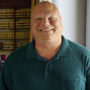 Smiling bald man in a law library